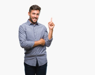 Kameraya bakarak yan el ve parmak ile işaret eden genç yakışıklı adam yüzünde kocaman bir gülümseme ile izole arka plan üzerinde.