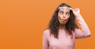 Güzel genç İspanyol kadın balık yapma güneş gözlüğü takıyor yüz dudaklı, çılgın ve komik bir jest. Komik ifade.