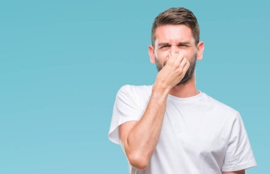 Yakışıklı delikanlı bir şey pis ve iğrenç kokulu izole arka plan, dayanılmaz koku, holding nefes burun parmaklar ile. Kötü kokuyor kavramı.