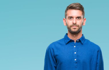 Yakışıklı delikanlı yüzünde ciddi bir ifade ile izole arka plan üzerinde. Basit ve doğal kameraya bakıyor.