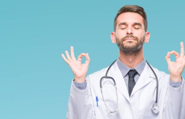 Genç yakışıklı Doktor adam izole arka plan üzerinde dinlenmek ve gülümseyen gözlerle parmak ile meditasyon jest yapıyor kapalı. Yoga kavramı.