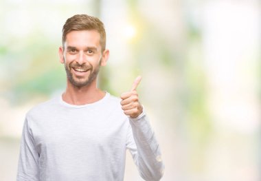 Yakışıklı delikanlı hareketi el ile mutlu yaşasın yapıyor izole arka plan üzerinde. Kameraya bakarak başarı gösteren ile ifade onaylama.