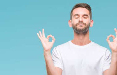 Yakışıklı delikanlı izole arka plan üzerinde dinlenmek ve gülümseyen gözlerle parmak ile meditasyon jest yapıyor kapalı. Yoga kavramı.