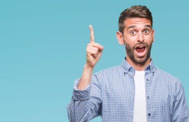 Başarılı fikirle izole arka plan işaret parmağı üzerinde beyaz t-shirt giyen genç yakışıklı adam. Çıktıktan ve mutlu. Bir numara.