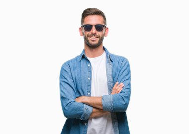 Yakışıklı delikanlı üzerinde güneş gözlüğü takıyor mutlu yüz ile gülümseyerek kameraya seyir silah geçti arka plan izole. Olumlu bir kişi.