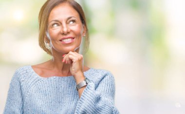 Üzerinde kış kazak giyen orta yaş üst düzey İspanyol kadın arka plan çene düşünme hakkında soru, dalgın ifade üzerine el ile izole. Düşünceli yüzüyle gülümsüyor. Şüphe kavramı.