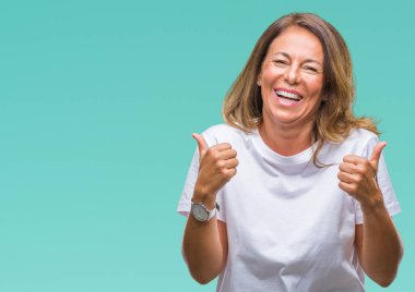 Orta yaş üzerinde el ile pozitif jest yapıyor izole arka plan başarı işareti İspanyol kadın kıdemli başparmak gülümseyen ve mutlu. Neşeli bir ifadeyle, kazanan jest kameraya bakıyor.