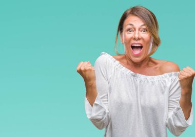 İzole arka plan kutlama üzerinde orta yaş İspanyol kadın kıdemli şaşırttı ve başarı için kaldırdı kollarını açarak hayret ve gözleri açık. Kazanan kavramı.