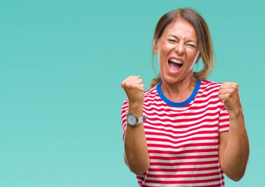 Gülümseyen ve başarı için çığlık orta yaş üst düzey İspanyol kadın izole arka plan çok mutlu ve heyecanlı kaldırdı, silah ile kazanan jest yapıyor. Kutlama kavramı.