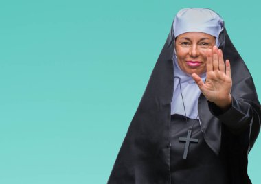 Orta yaş üst düzey Hıristiyan Katolik Rahibe kadın izole arka stop yapıyor yüzünden elin avuç ile şarkı. Negatif ve ciddi bir jest yüz ifadesiyle uyarı.