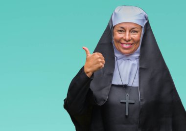 Orta yaş üst düzey Hıristiyan Katolik Rahibe kadın arıyorum ve başparmak yanında yukarıyı mutlu yüz ile gülümseyen izole arka plan.