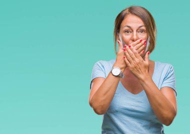 Orta yaş üst düzey İspanyol kadın izole arka plan ağız hata için elleriyle kapsayan şok yüzünden. Gizli kavramı.