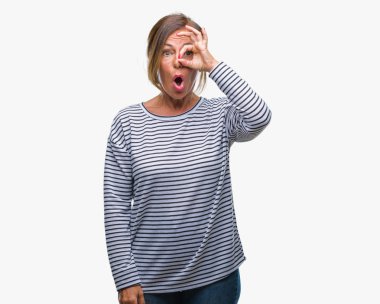 Orta yaş ok jest yapıyor izole arka plan üzerine İspanyol kadın kıdemli sürpriz yüz, göz parmaklarının arasından seyir ile şok. İmansız ifade.