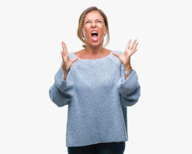 Üzerinde kış kazak giyen orta yaş üst düzey İspanyol kadın arka plan deli izole ve deli bağırarak ve agresif ifade ve silah kaldırdı bağırıyor. Hayal kırıklığı kavramı.