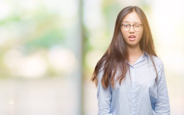 Seksi bir ifadeyle, neşeli ve mutlu yüzünü kameraya bakarak göz kırpıyor izole arka plan üzerinde gözlük takan genç Asya iş kadını.