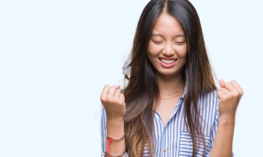 Gülümseyen ve başarı için çığlık Genç Asyalı kadın izole arka plan çok mutlu ve heyecanlı kaldırdı, silah ile kazanan jest yapıyor. Kutlama kavramı.