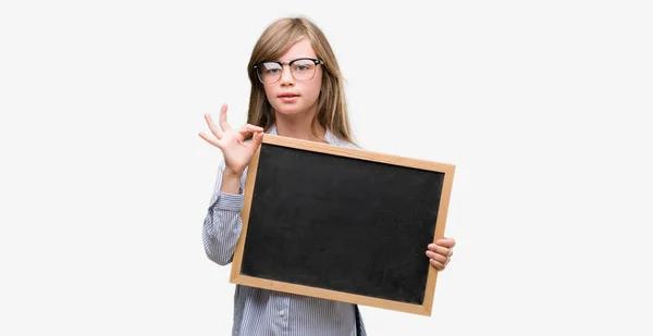 Young Blonde Child Holding Blackboard Doing Sign Fingers Excellent Symbol — Stock Photo, Image