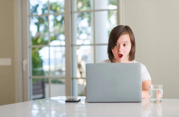 唐氏综合症妇女在家里使用电脑笔记本电脑害怕休克与惊讶的脸 害怕和兴奋的表情恐惧表达 — 图库照片
