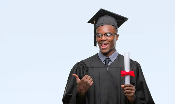 Joven Hombre Afroamericano Graduado Sosteniendo Grado Sobre Fondo Aislado Señalando — Foto de Stock