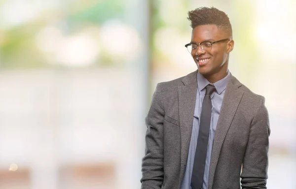 Young african american business man over isolated background looking away to side with smile on face, natural expression. Laughing confident.