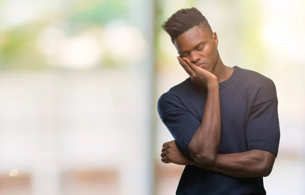 Young african american man over isolated background thinking looking tired and bored with depression problems with crossed arms.