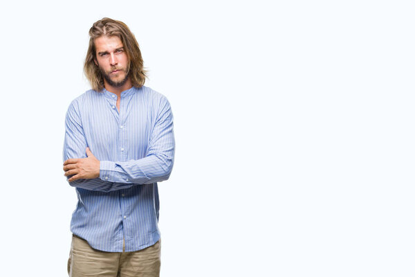 Young handsome man with long hair over isolated background skeptic and nervous, disapproving expression on face with crossed arms. Negative person.