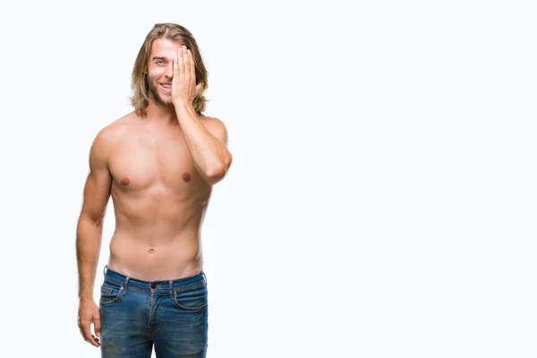 年轻英俊的裸男与长发显示性感的身体在孤立的背景覆盖一只眼睛与自信的笑容脸上和惊喜的情绪 — 图库照片