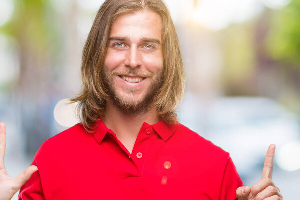 Young handsome man with long hair over isolated background showing and pointing up with fingers number six while smiling confident and happy.