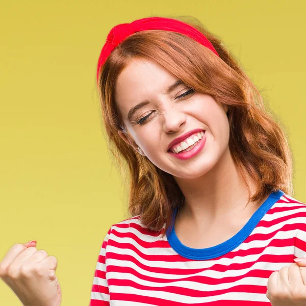 Gülümseyen ve başarı için çığlık genç güzel kadın izole arka plan çok mutlu ve heyecanlı kaldırdı, silah ile kazanan jest yapıyor. Kutlama kavramı.