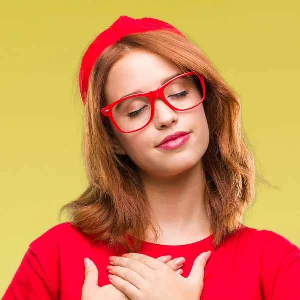 Genç güzel kadın ile gülümseyen izole arka plan yüzünden kapalı gözler ve yüzünde minnettar jest ile göğüs üzerinde eller. Sağlık kavramı.