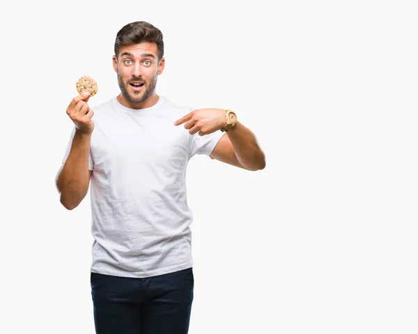 Young Handsome Man Eating Chocolate Chips Cookie Isolated Background Surprise — Stock Photo, Image