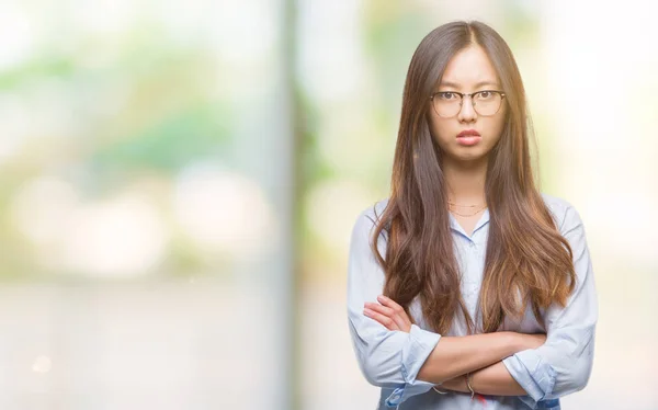 若いアジア ビジネス女性懐疑的な孤立した背景と組んだ腕で顔の神経 不賛成式メガネを着用します 否定的な人 — ストック写真