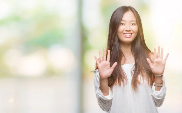 年轻的亚洲妇女在孤立的背景显示和指向手指数十 而微笑着自信和快乐 — 图库照片