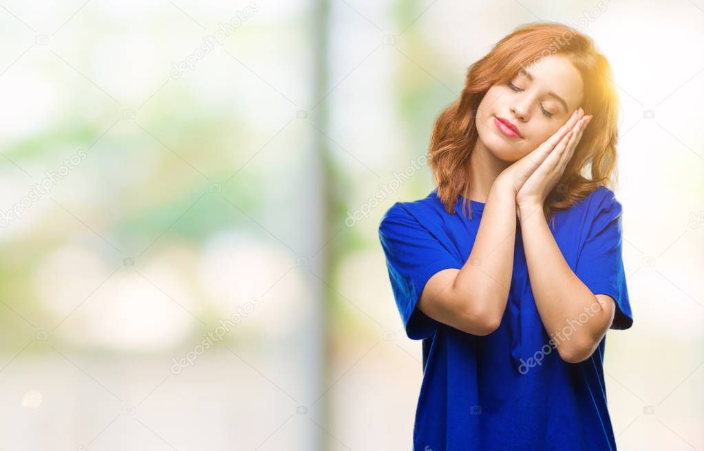 Young beautiful woman over isolated background sleeping tired dreaming and posing with hands together while smiling with closed eyes.