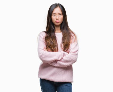 Genç Asyalı kadın izole arka plan şüpheci ve çapraz kolları olan yüzündeki gergin, onaylamayan ifade yüzünden. Negatif kişi.