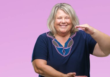 Kıdemli artı boyutu ile büyük ve büyük boy işaret, ölçü birimi sembol gösteren el el hareketi arka plan üzerinde beyaz kadın izole. Kameraya bakarak gülümsüyordu. Ölçüm kavramı.