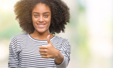 Genç afro Amerikan kadın hareketi el ile mutlu yaşasın yapıyor izole arka plan yüzünden. Kameraya bakarak başarı gösteren ile ifade onaylama.