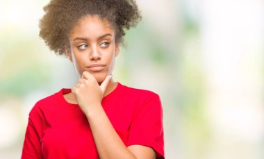 Emin çapraz kollar ve çeneme kaldırdı el ile gülümseme ile kameraya bakarak izole arka plan üzerinde genç afro Amerikalı kadın. Pozitif düşünce.