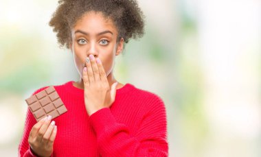 Hata, korku, sessizlik içinde gizli kavramı korkmuş ifade için utanç ile izole arka kapak ağız el ile üzerinden çikolata yeme genç afro Amerikalı kadın şok