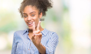 Zafer işareti yapıyor parmak gösterilen kamera seyir gülümseyen izole arka plan üzerinde genç afro Amerikalı kadın. İki numaralı.