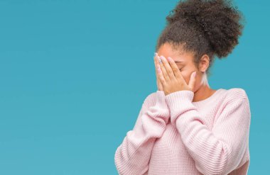 Yüzünü elleriyle ağlayarak süre kapsayan üzgün ifade ile izole arka plan üzerinde kış kazak giyen genç afro Amerikan kadın. Depresyon kavramı.