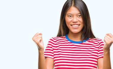 Genç Asyalı kadın kutluyor izole arka plan üzerinde şaşırttı ve başarı için kaldırdı kollarını açarak hayret ve gözleri açık. Kazanan kavramı.