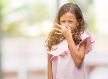 Bir şey pis ve iğrenç kokulu pembe elbise, dayanılmaz koku, holding nefes parmak ile burnuna giyen esmer Latin kız. Kötü kokuyor kavramı.