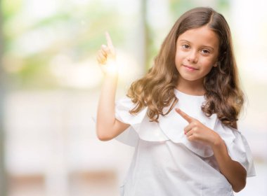 Gülümseyen ve iki ile işaret kamera bakarak esmer Latin kız eller ve yan parmak.