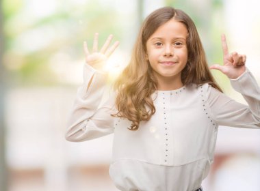 Gösterilen ve parmakları ile işaret esmer Latin kız kendinden emin ve mutlu gülümseyerek süre yedi numara.