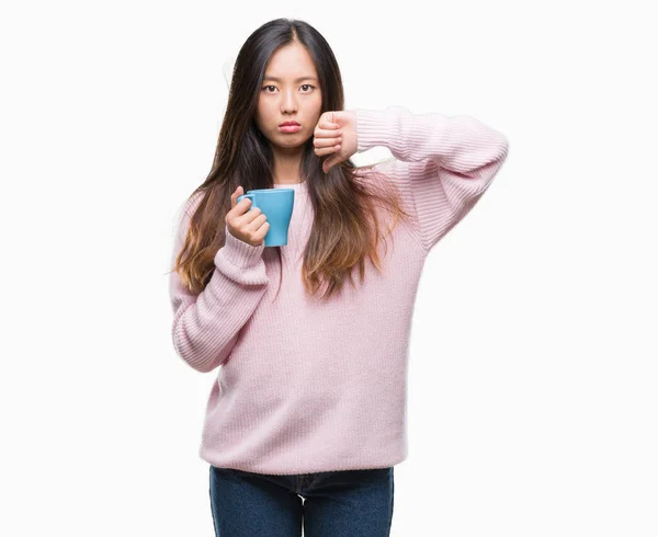 怒った顔 ダウン親指で嫌悪感を示すマイナス記号 拒絶反応の概念と分離の背景の上にコーヒーを飲む若いアジア女性 — ストック写真