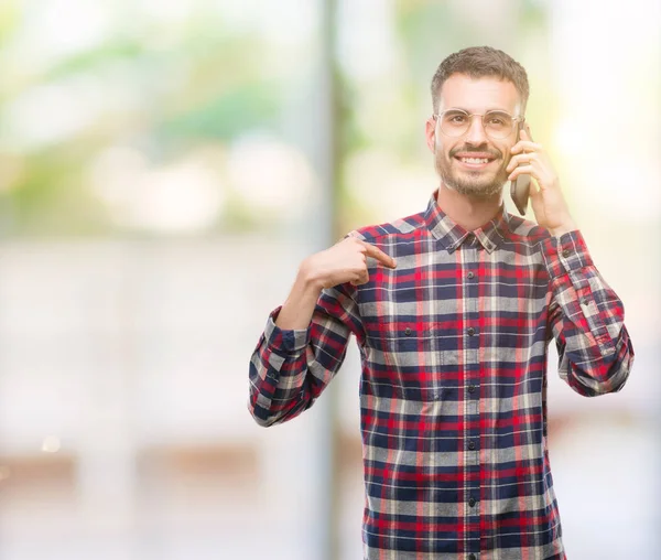 Kendisi için sürpriz yüz işaret parmağı ile telefonda konuşan genç yenilikçi yetişkin adam