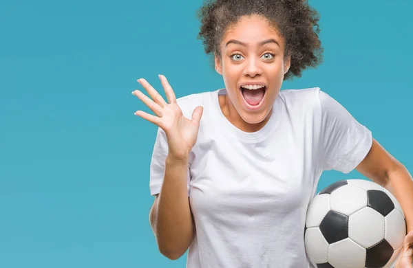 年轻美丽的美国黑人举行足球足球在孤立的背景下非常高兴和兴奋 优胜者表达庆祝胜利尖叫与大微笑和举手 — 图库照片