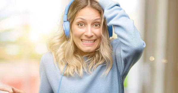 Joven Hermosa Mujer Escuchando Música Apuntando Hacia Lado Con Dedo — Foto de Stock