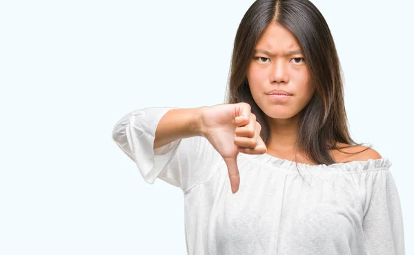 年轻的亚洲妇女在孤立的背景看不开心和愤怒显示拒绝和否定与拇指向下手势 错误的表达式 — 图库照片